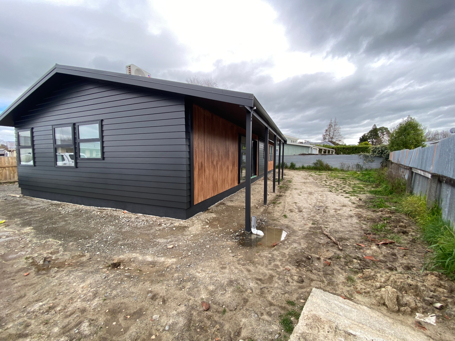 Modern black weatherboard home with cedar accent panel