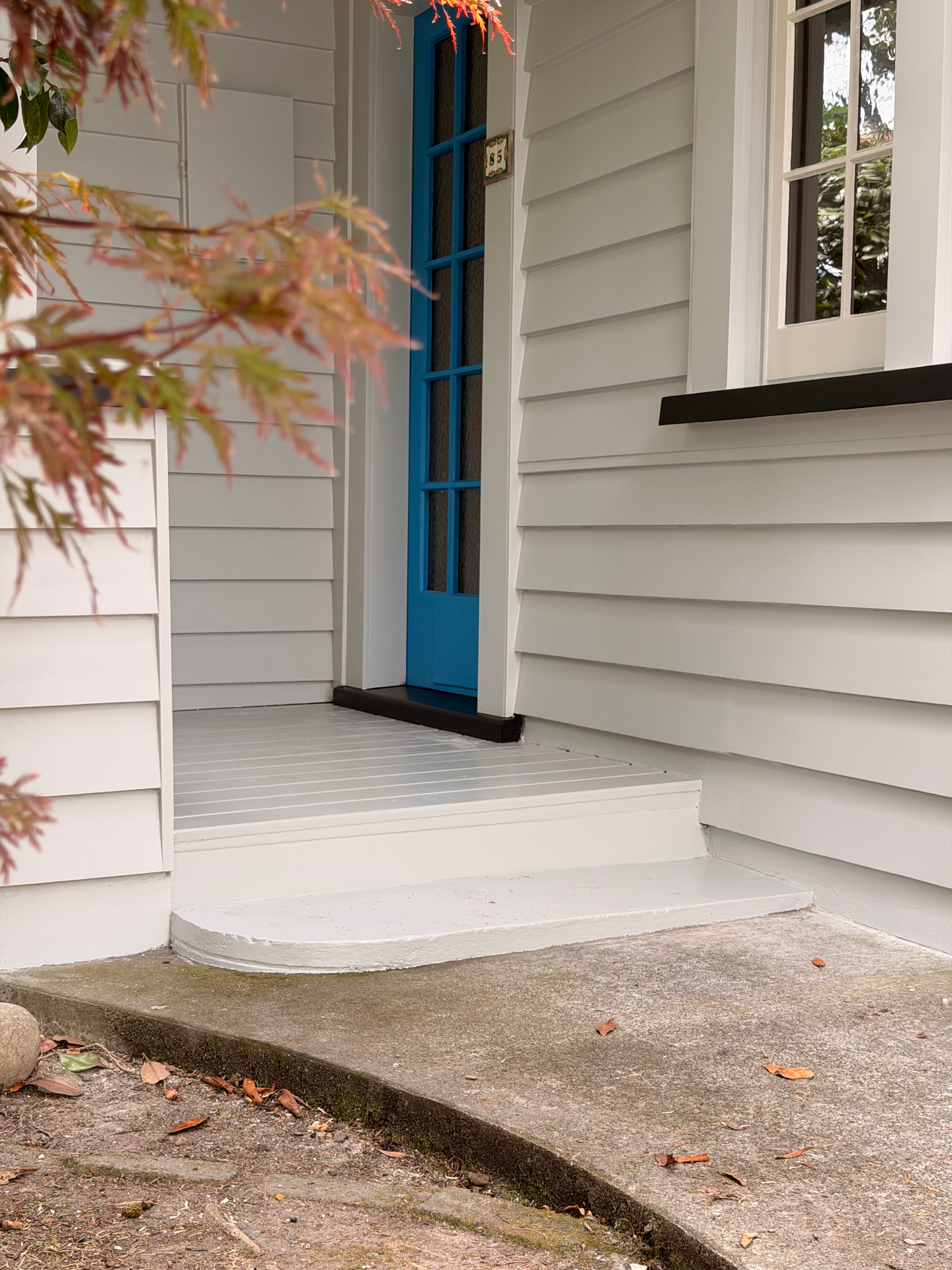 Freshly painted weatherboard entry with vibrant blue door