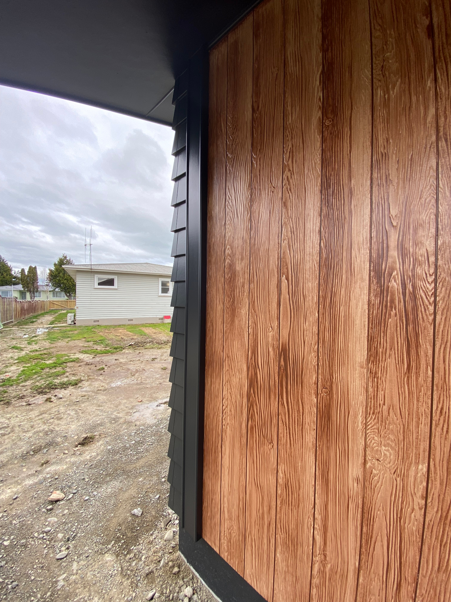Crisp cedar feature wall against charcoal weatherboard exterior