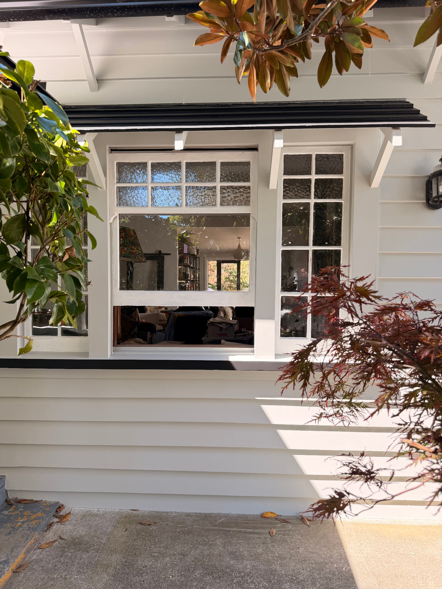 Restored villa window joinery with fresh white paint and black trim